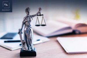 waage der justitia bücher auf dem tisch