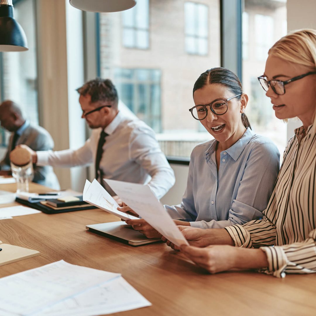 two-smiling-businesswomen-going-over-paperwork-at-LLDYSYA-1.jpg Teamwork in der Kanzlei
